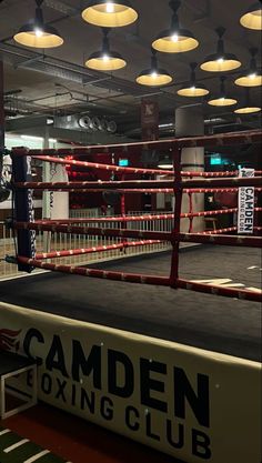 an empty boxing ring with lights hanging from the ceiling