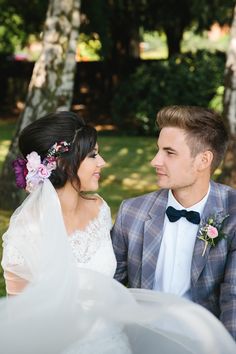 the bride and groom are sitting together outside