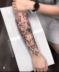 a woman's arm with flowers and butterflies on it