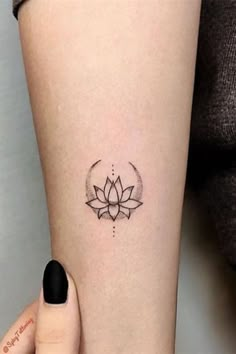 a woman's leg with a lotus tattoo on the left side of her arm