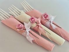 three pink and white napkins with flowers on them are sitting next to each other