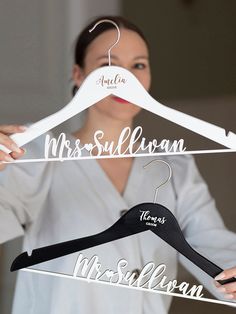 a woman is holding two personalized hangers