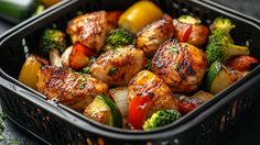 a plastic container filled with chicken, broccoli and peppers on top of a table