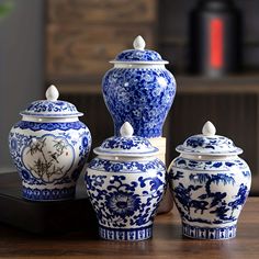 three blue and white vases sitting on top of a wooden table