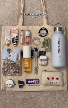 a tote bag filled with personal items on top of a carpeted floor next to a handbag