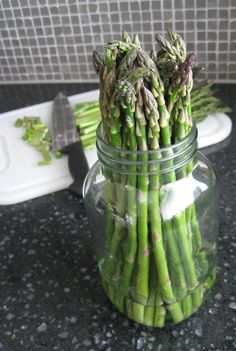 asparagus in a glass jar sitting on a counter