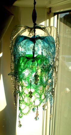 a green glass chandelier hanging from a ceiling in front of a white wall