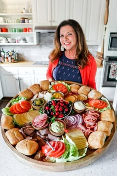 a woman standing in front of a large platter of food