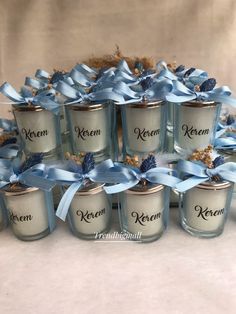 twelve glass jars with blue bows and labels on them