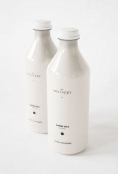 two white bottles sitting next to each other on a white surface with no one around them