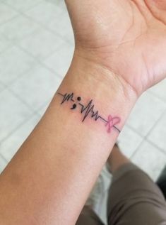 a woman's wrist with a heartbeat tattoo on it