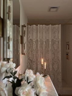 a bathroom with candles and flowers on the counter