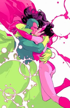 two people hugging each other in front of pink and green paint