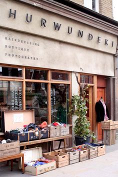 the outside of a clothing store with boxes and suitcases