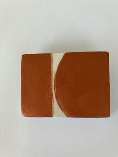 a piece of brown and white material on a white surface with an orange circle in the center