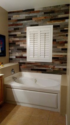 a bathroom with a bathtub, sink and large mirror on the wall above it