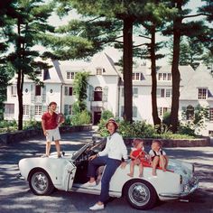 people are riding in an old car on the street