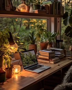 an open laptop computer sitting on top of a wooden desk in front of a window