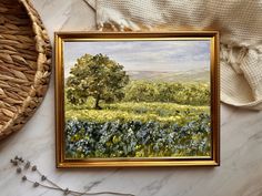 a painting is hanging on the wall next to a wicker basket and other items