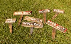 four wooden signs that are on the grass