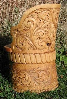 a carved wooden chair sitting in the grass