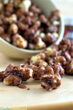 a bowl full of nuts sitting on top of a cutting board