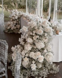 a table with white flowers and candles in the center is set up for a formal function