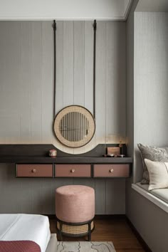 a bedroom with a bed, stool and mirror on the wall next to a window