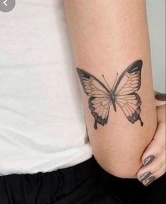 a woman's arm with a butterfly tattoo on the left side of her arm