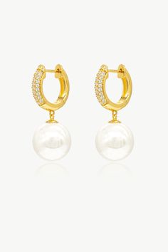 This pair of earrings features a lustrous solitaire shell pearl and a radiant hoop, creating a harmonious balance of classic and modern. The delicate huggie hoop is adorned with brilliant pavé set zirconia, adding a touch of sparkle and glamour that beautifully complements the pearls.These earrings effortlessly transition from day to night, from casual to formal events. Whether you're attending a wedding, a dinner party, or simply adding a touch of luxury to your everyday attire, these earrings Pearl Drop Earrings Gold, Pearl Dangle Earrings, Earrings Minimalist, Pearl Size, Pearl Drop Earrings, Gold Hoop, Pearl Drop, Dinner Party, Jewelry Earrings Dangle