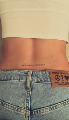 the back of a woman's stomach with a tattoo on it