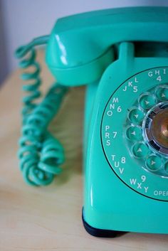 an old green phone sitting on top of a wooden table next to a quote that reads, i just wanna hear you say hello