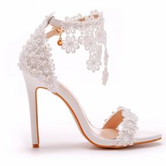 a white high heeled sandal with lace and pearls