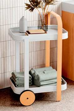 a small white cart with towels on it