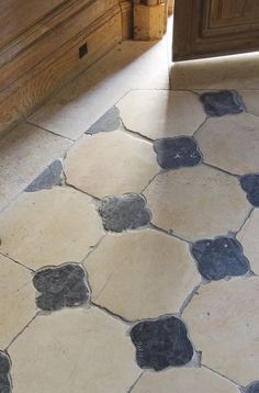 a kitchen floor with blue and white hexagonal tiles on the bottom half of it