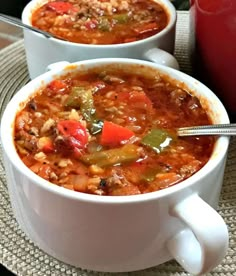 two white bowls filled with soup on top of a table