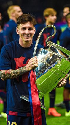 a man holding a soccer trophy on top of a field