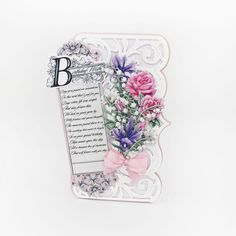 a card with pink roses and purple flowers on it, in front of a white background