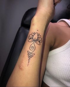 a woman's arm with a flower tattoo on the left side of her arm