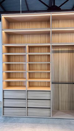 an empty closet with wooden shelves and drawers