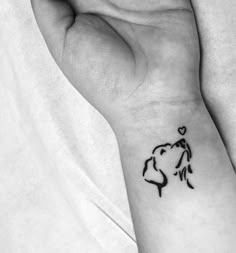 a woman's wrist with a small tattoo design on the left side of her arm