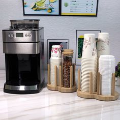 there are many cups on the counter next to each other and a coffee maker in front of them