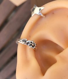 an ear with two silver stars on top of it, sitting next to a wooden surface