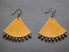 two pairs of leather earrings with beads on them