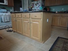 a kitchen with wooden cabinets and tile flooring