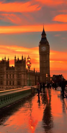 the big ben clock tower towering over the city of london at sunset with people walking in the rain