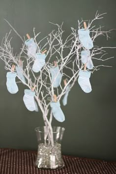 a glass vase filled with baby shoes on top of a table