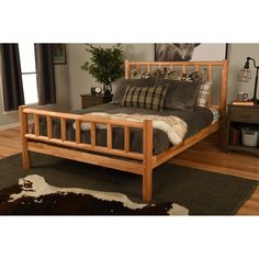 a wooden bed frame in a room with wood floors and rugs on the floor