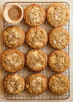 freshly baked cookies on a cooling rack next to a bowl of oatmeal