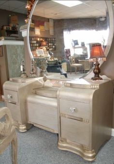 an antique vanity with a large round mirror on it's side and a chair in the foreground